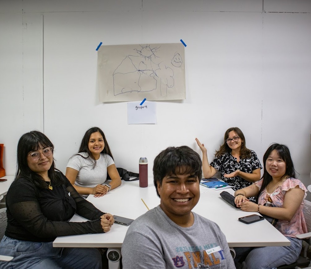 5 students a table during class in Costa Rica to present their project