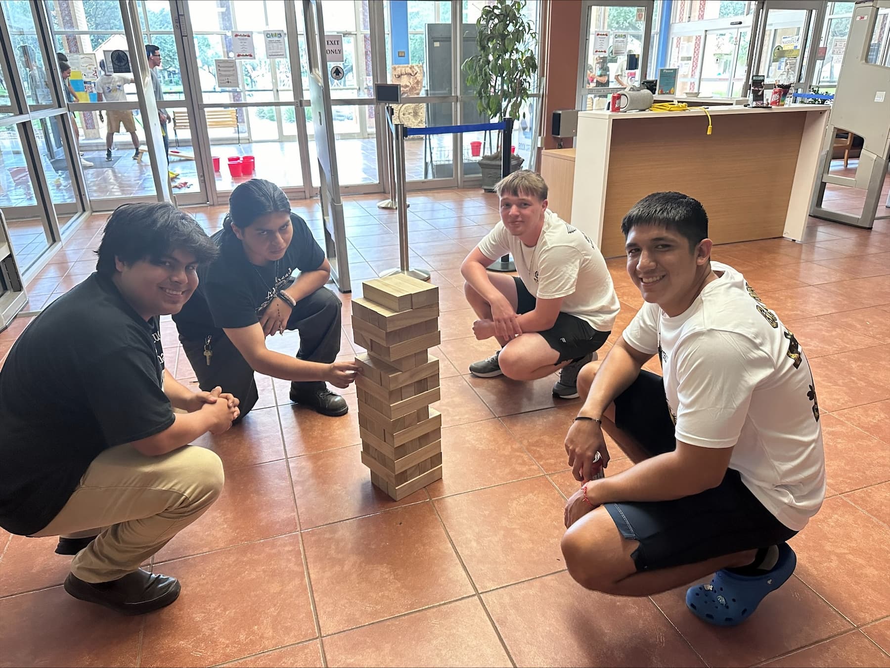 four students playing Jenga in the residence hall.