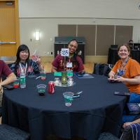 Group of 5 smiling and sitting around a black table