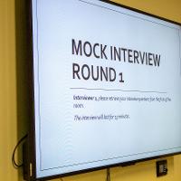 A TV the reads "Mock Interview Round 1"