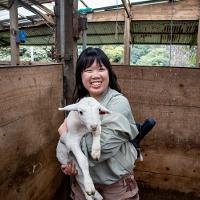 girl holding a goat smiling