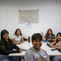 Group of 6 smiling, sitting at a table